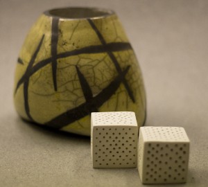 En gröngul keramikvas och två vita kuber i keramik