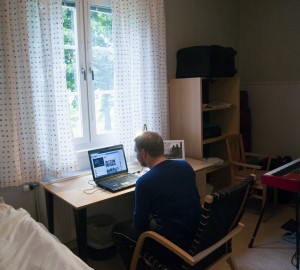 Deltagare sitter vid datorn i sitt rum i Gästhemmet.