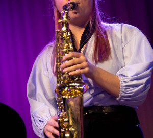 En saxofonist spelar med slutna ögon.