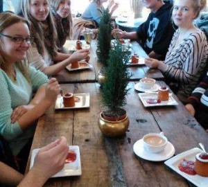 Deltagare samlade runt ett bord med Runebergsbakelser