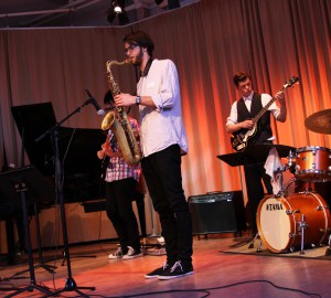 Fem elever från jazz-, pop- och rocklinjen spelar på scen i aulan.