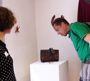 Besökare tittar på en väska som ställts ut i konsthuset.