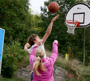 En person hoppar och blockerar en basketboll som kastats.