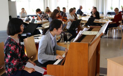 Två deltagare vid ett piano i Kävestas matsal.