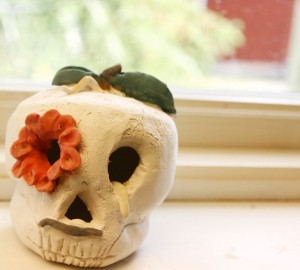 En dödskalle i keramik, med en blomma i ena ögat.