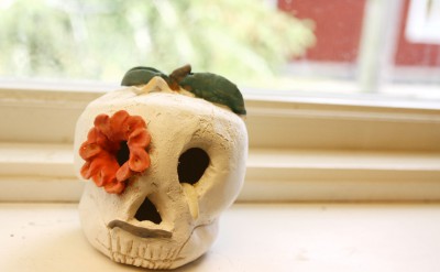 En dödskalle i keramik, med en blomma i ena ögat.