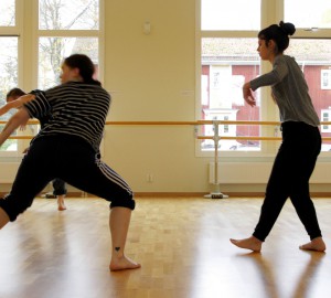 Tre dansare mitt i rörelser över golvet.