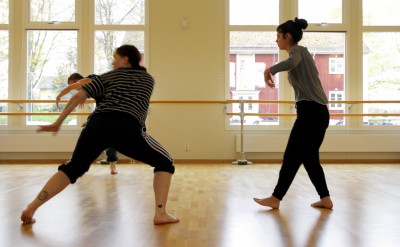 Tre dansare mitt i rörelser över golvet.