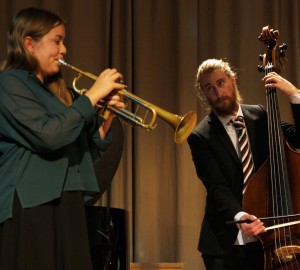 Jazzensemble, en person spelar trumpet i förgrunden. I bakgrunden spelar en person ståbas med stråke.