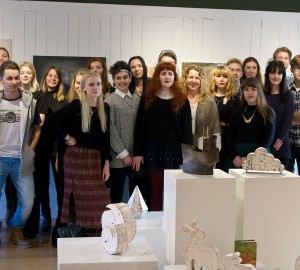 Gruppbild på deltagarna på Konst & formgivningslinjen, framför några vita piedestaler med keramikskulpturer på.