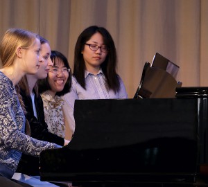 Tre deltagare från musiklinjens klassiska inriktning spelar sexhänt piano.