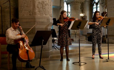 Tre klassiska musiker spelar stråkisntrument.