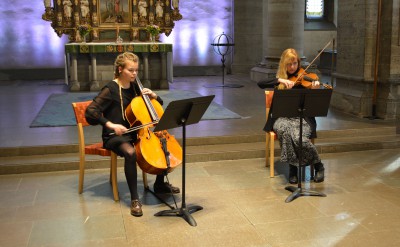 Två klassiska musiker i kyrkan, viola och fiol.