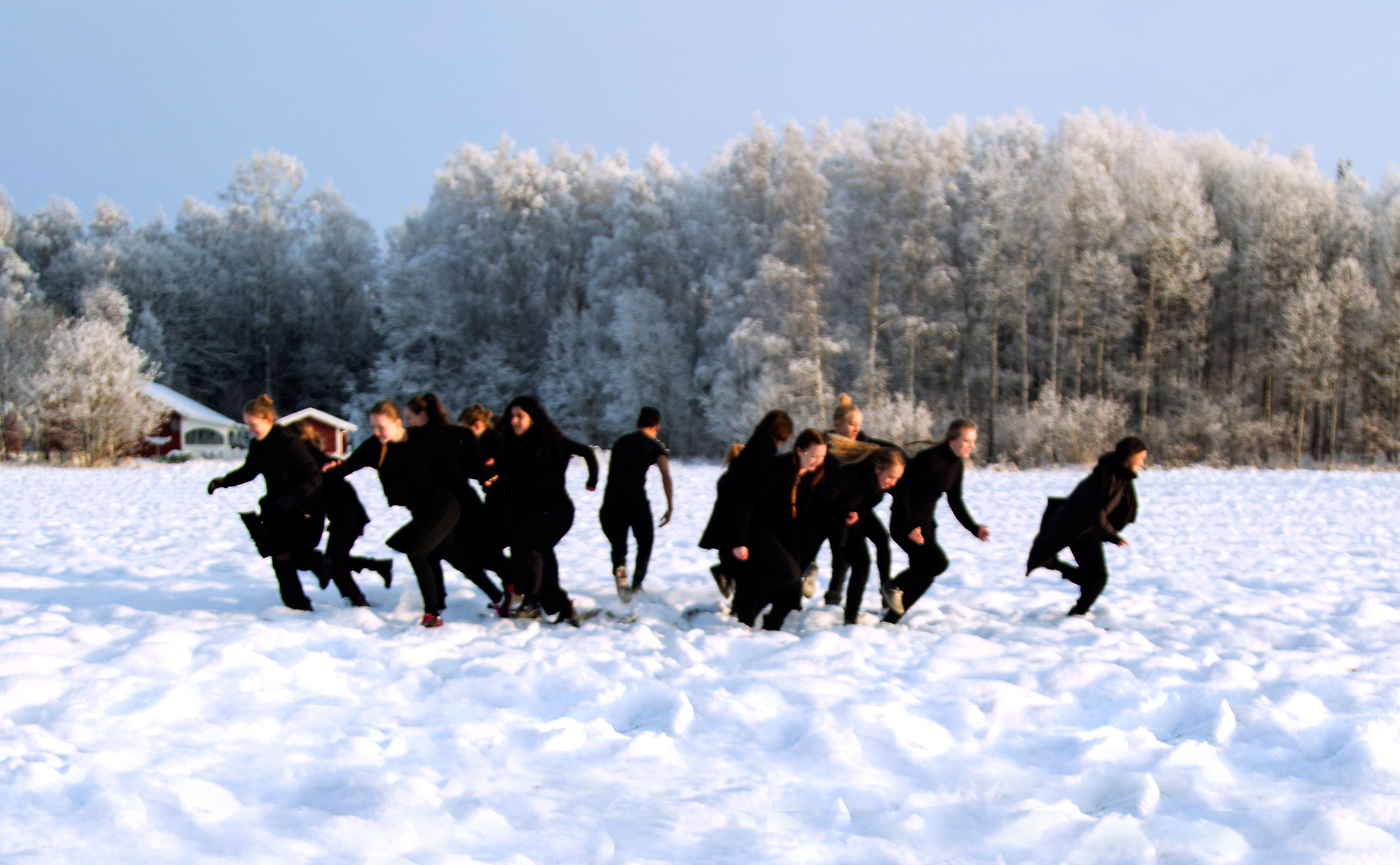 Ett vinterlandskap där svartklädda personer springer åt olika håll.