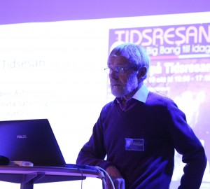 Roland Almqvist föreläser vid ett podium i Kävestas aula.