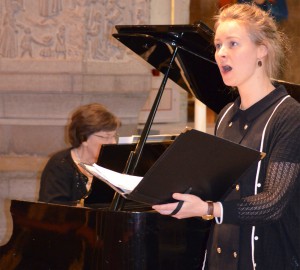 En deltagare sjunger, ackompanjerad av piano.