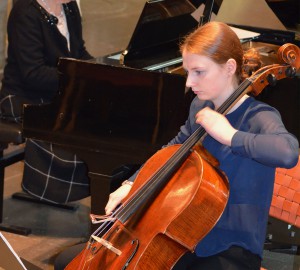 En deltagare spelar cello, ackompanjerad av piano.