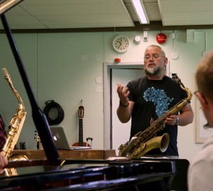 Karl-Martin Almqvist pratar med en saxofonist och en pianist under repetitionerna.