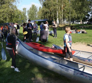 Deltagare bär ner en kanot till vattnet.