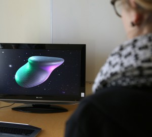 En skärm med ett vågigt 3D-objekt som skiftar i olika neonfärger.