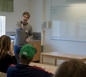 En lärare talar till en grupp sittande deltagare.