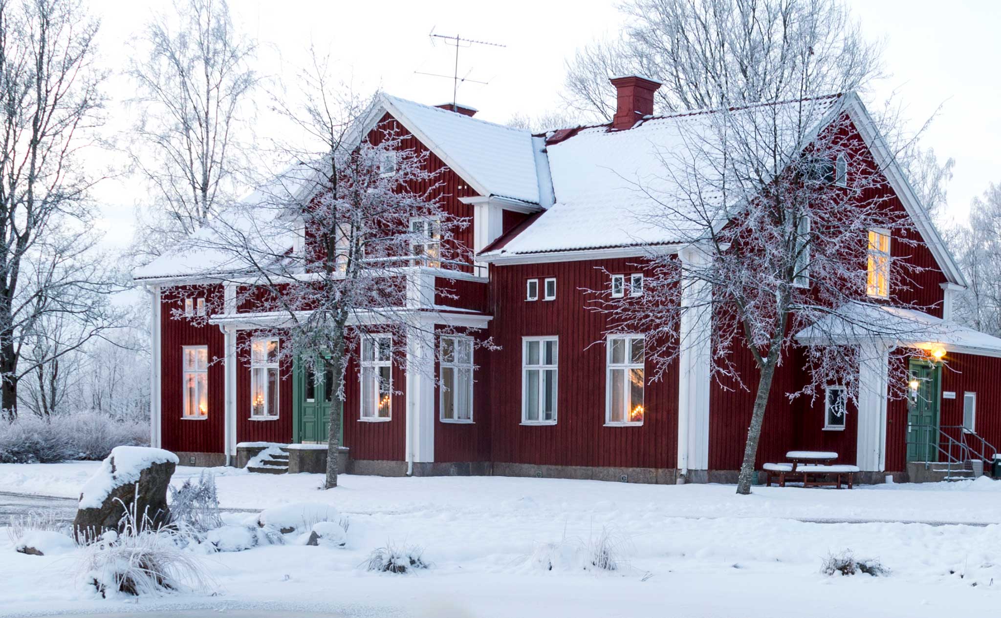 Ett rött hus täckt av vit snö.