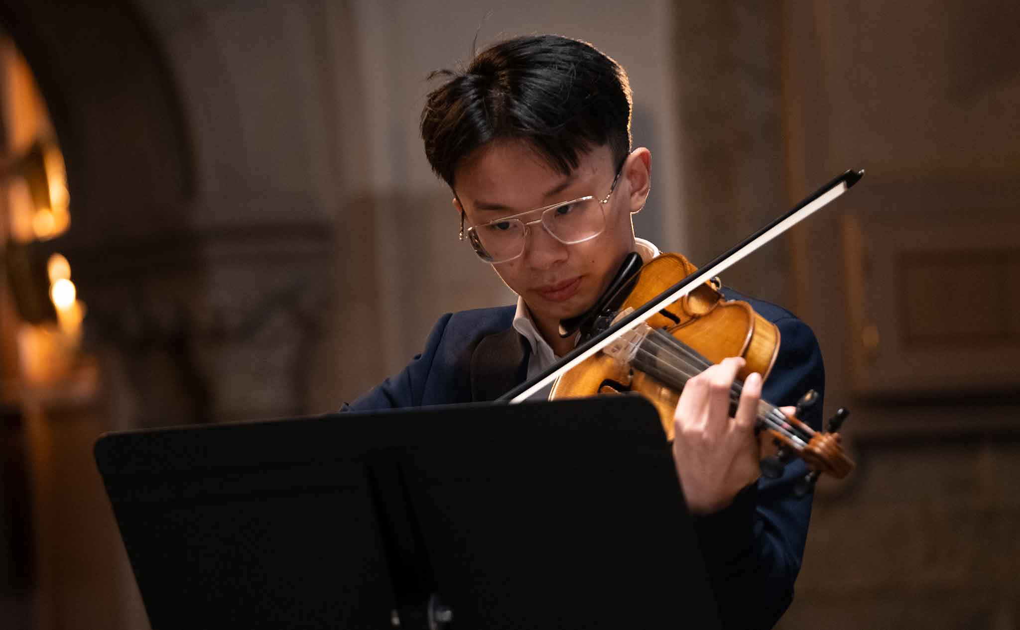 Närbild på en violinist i en kyrka.